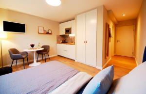 a bedroom with a bed and a table and a kitchen at Apartmenthaus Schön in Bad Neustadt an der Saale