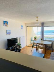 Sala de estar con mesa y vistas al océano en Logement entier vue sur mer !, en Palavas-les-Flots