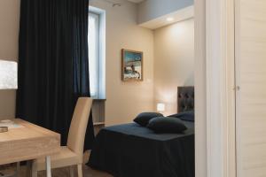1 dormitorio con cama, escritorio y ventana en Valditerra Vini - B&B La Rombetta en  Tassarolo
