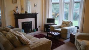 a living room with a couch and a fireplace at Easter Garth Guest House in Helensburgh