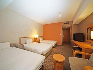 a hotel room with two beds and a television at LOISIR HOTEL SHINAGAWA SEASIDE in Tokyo