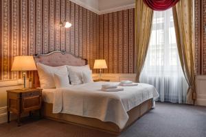 1 dormitorio con 1 cama con 2 lámparas y una ventana en Hotel Praga 1885 en Praga