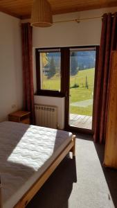 a bedroom with a bed and a large window at Haus Izabella in Filzmoos