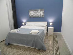 niebieska sypialnia z łóżkiem z ręcznikami w obiekcie Chiarini22 Apartments w mieście Neapol