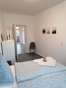 a white room with a bed and a chair at Apartment Bona Loca in Aschersleben