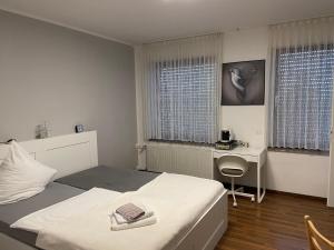 1 dormitorio con cama, escritorio y ventana en Hotel-Kronenhof, en Julich
