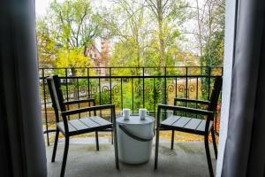 a balcony with two chairs and a table with two candles at aappartel APARTHOTEL Herford in Herford +44 photos