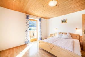 Schlafzimmer mit einem Bett und einem Fenster in der Unterkunft Egarthof Ferienwohnung Alpenrose in Moos in Passeier