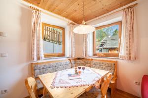 una sala da pranzo con tavolo, sedie e finestra di Egarthof Ferienwohnung Alpenrose a Moso