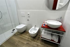 a white bathroom with a sink and a toilet at Hotel Aurea in Rimini