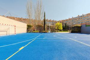 an empty basketball court in a parking lot at Los Olivos Stylish Apartments in Conde Orgaz Area in Madrid