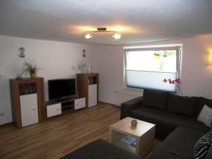 a living room with a couch and a flat screen tv at Fewo Fischerhus in Zempin
