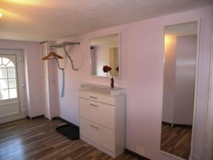 a white room with a dresser and a mirror at Fewo Fischerhus in Zempin +11 photos