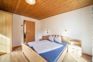 a bedroom with a bed and a wooden ceiling at Egarthof Ferienwohnung Enzian in Moso