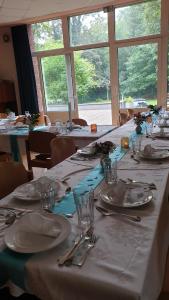 a long table with white plates and silverware on it at Naturfreundehaus Gelsenkirchen in Gelsenkirchen