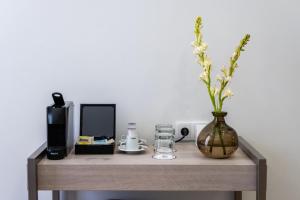 a wooden table with a vase with a flower in it at Soho Boutique Urban in Málaga
