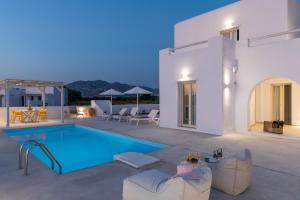 a villa with a swimming pool at night at Naxian Lounge Villas in Naxos Chora