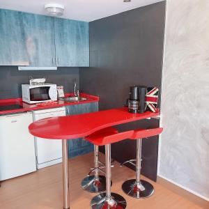 a red counter in a kitchen with a red table at Confortable Lake Placid in Pas de la Casa
