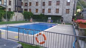 a swimming pool with two chairs and a life preserver at Alojamiento Mundarrey Bïescas in Biescas