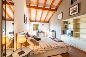 a bedroom with a large bed in a room with a kitchen at CASA LUNA ALMA in Brione sopra Minusio +74 photos