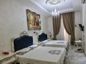 a bedroom with two beds and a chandelier at innstation guesthouse in Rome +13 photos