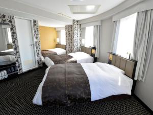 a hotel room with two beds and two windows at APA Hotel Toyohashi-Ekimae in Toyohashi