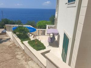 a balcony with a blue surfboard on the side of a building at Apartments Villa Bella Vista in Gornji Dingač