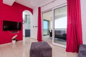 a living room with red walls and sliding glass doors at Apartments Villa Bella Vista in Gornji Dingač