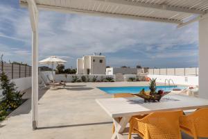 a patio with a table and chairs and a pool at Naxian Lounge Villas in Naxos Chora