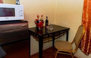 a small table with a microwave and a table with a chair at Harmony Inn & Secret Villa in Georgetown