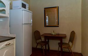 a small kitchen with a table and a refrigerator at Harmony Inn & Secret Villa in Georgetown