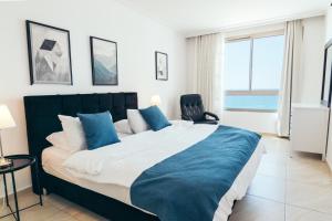 Een bed of bedden in een kamer bij Almog Beach Apartments מגדלי חוף הכרמל חיפה