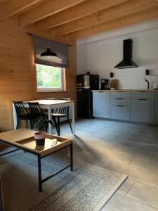 een woonkamer met een tafel en een keuken bij Domki Skandynawskie Kopalino in Kopalino