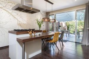 a kitchen with a wooden table and chairs at B&B De Mansarde in Apeldoorn