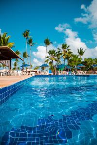 una piscina en un complejo con palmeras en el fondo en Jardim Atlântico Beach Resort, en Ilhéus