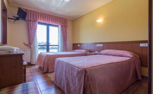 een hotelkamer met 2 bedden en een raam bij Hostal Restaurante O'Cadaval in Frades