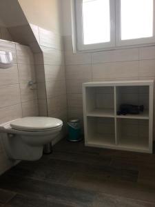 La salle de bains est pourvue de toilettes et d'une fenêtre. dans l'établissement FeWo Carstensen, à Fehmarn