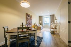 a dining room with a table and a living room at Casa Calmaria Beja in Beja
