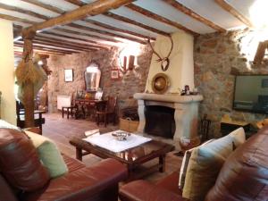 un soggiorno con divano e camino di Casa Rural La Luciérnaga Salamanca a Sorihuela