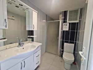 a bathroom with a sink and a toilet and a shower at Berrak Su Hotel in Antalya