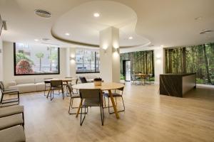 un vestíbulo con mesas y sillas y un sofá en Apartamento Sadio - Residencial Infinity en Estepona