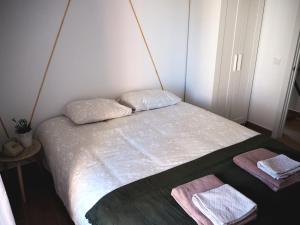 1 dormitorio pequeño con 1 cama con 2 toallas en La Casa de los Abuelos Valentín, en Pinilla del Valle