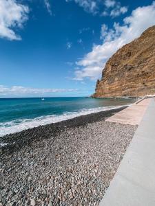 uma praia com o oceano e uma costa rochosa em The Palms Apartment em Madalena do Mar