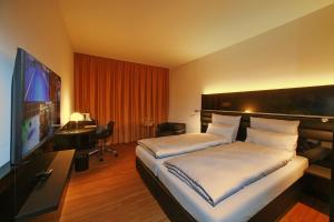 een hotelkamer met een bed en een flatscreen-tv bij The Bridgge Grand Boutique Hotel in Brüggen