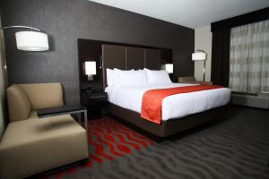 a hotel room with a large bed and a chair at Holiday Inn Express & Suites Monroe, an IHG Hotel in Monroe