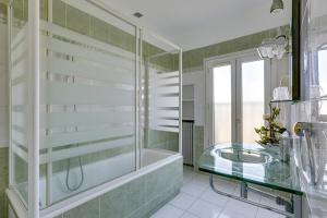 a bathroom with a glass tub and a glass sink at Hôtel du Square d'Anvers in Paris