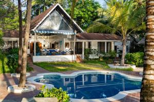 a house with a swimming pool in front of a house at Asha Boutique Hotel in Diani Beach