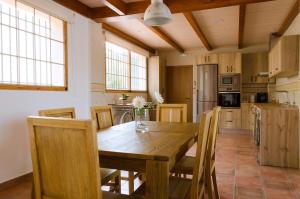 a dining room with a wooden table and chairs at Las Palmeras Playamonte in Navarrés