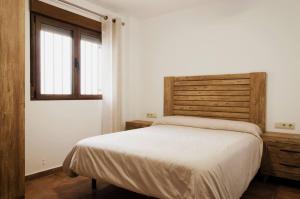 a bedroom with a large bed and a window at Las Palmeras Playamonte in Navarrés
