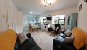 a living room with a couch and a kitchen at Moyola River Cottage in Magherafelt